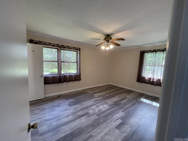 spare room featuring ceiling fan, ornamental molding, and dark wood-type flooring