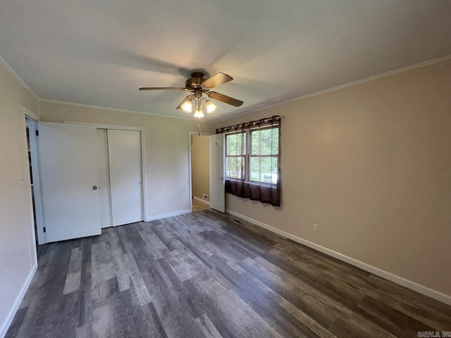 unfurnished bedroom featuring ceiling fan, dark hardwood / wood-style floors, crown molding, and a closet