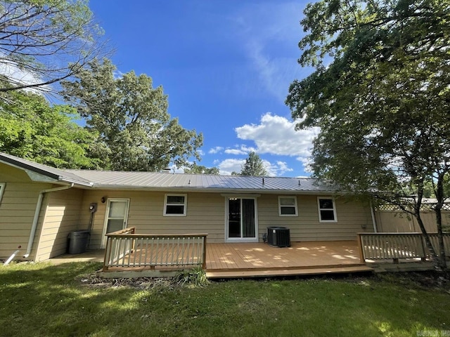 rear view of property featuring central AC unit, a lawn, and a wooden deck