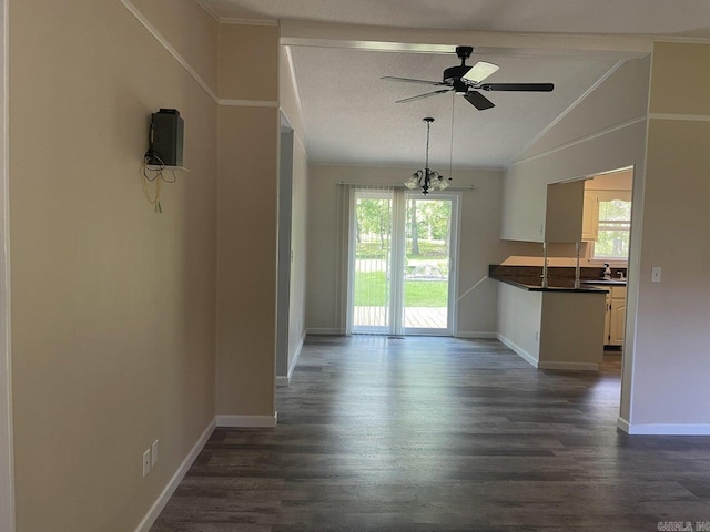 interior space featuring ceiling fan with notable chandelier, dark hardwood / wood-style floors, crown molding, and lofted ceiling