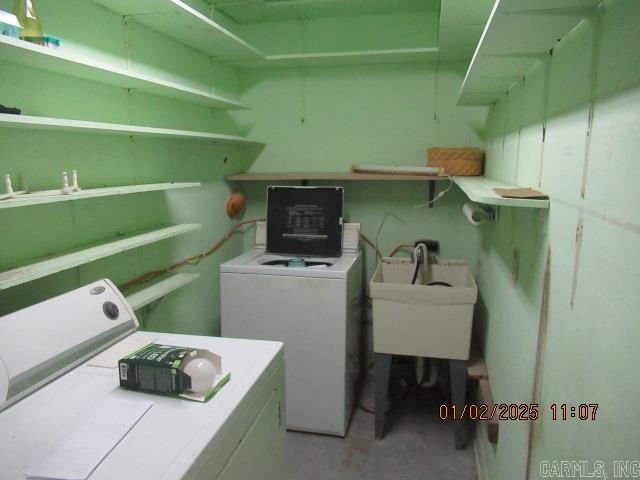 clothes washing area with a sink, washer and clothes dryer, and laundry area