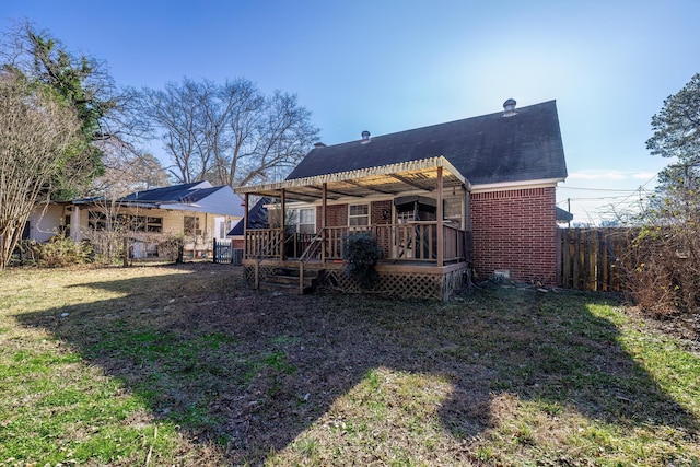 back of house featuring a wooden deck and a yard