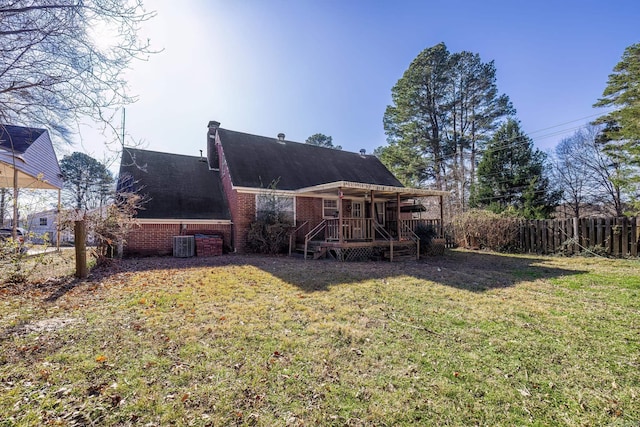 rear view of property with a lawn and a wooden deck