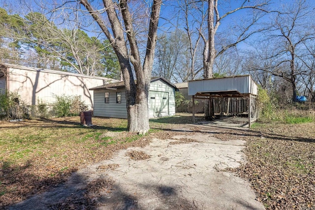 exterior space with a lawn, an outbuilding, and a carport