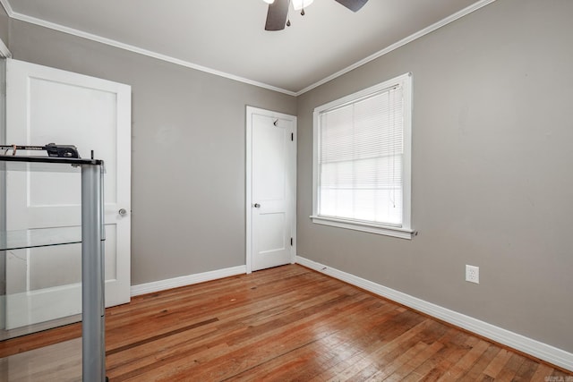 unfurnished room featuring ceiling fan, light wood-type flooring, and crown molding