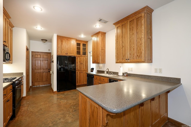 kitchen with kitchen peninsula, sink, black appliances, and a breakfast bar