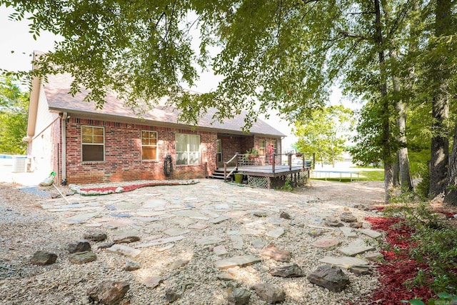 rear view of property featuring a wooden deck