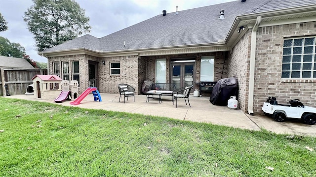 rear view of property with a lawn and a patio area