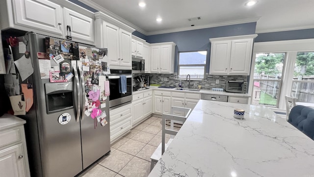 kitchen with sink, stainless steel appliances, light tile patterned floors, decorative backsplash, and white cabinets