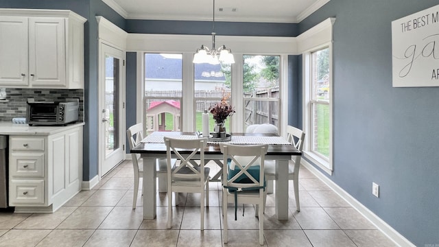 dining space with a healthy amount of sunlight, ornamental molding, and an inviting chandelier