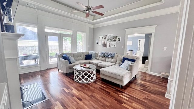 living room with ceiling fan, dark hardwood / wood-style floors, ornamental molding, and a tray ceiling