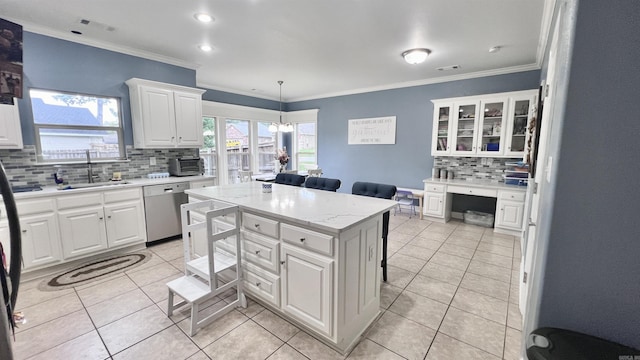 kitchen with stainless steel dishwasher, sink, pendant lighting, white cabinets, and a kitchen island