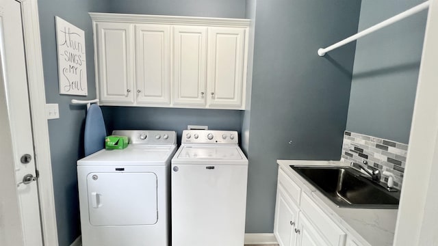 laundry room with cabinets, washing machine and dryer, and sink