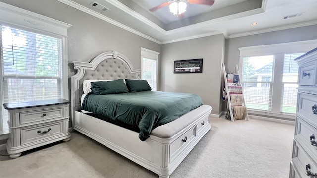 bedroom featuring ornamental molding, a tray ceiling, ceiling fan, and light colored carpet