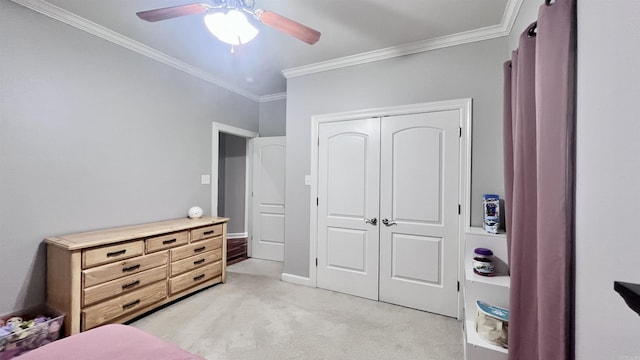 carpeted bedroom featuring ceiling fan, crown molding, and a closet