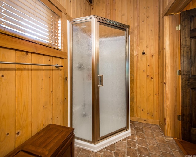 bathroom with wooden walls and a shower with shower door