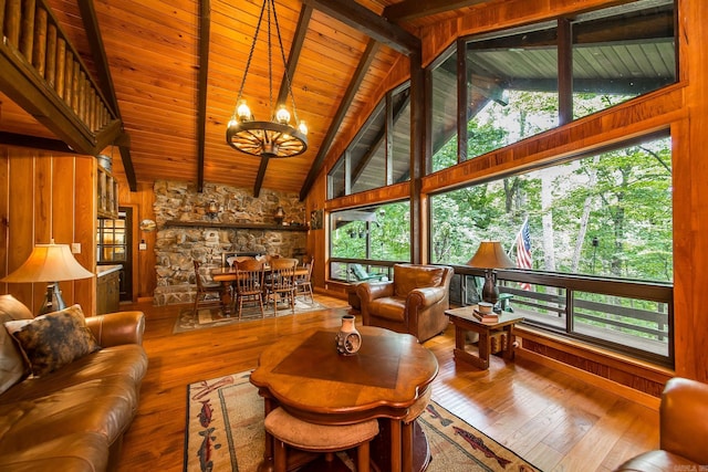 living room featuring beam ceiling, wood ceiling, a chandelier, and hardwood / wood-style flooring