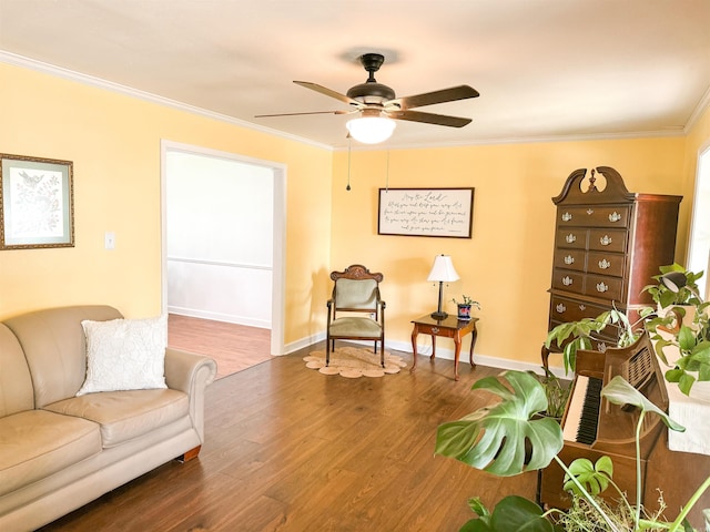 living area with wood-type flooring, ceiling fan, and ornamental molding