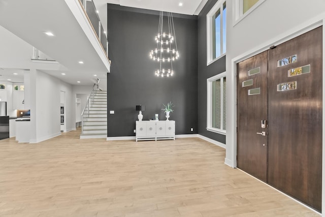 entrance foyer featuring light hardwood / wood-style flooring and a towering ceiling