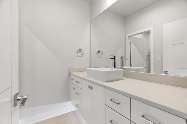 bathroom with a shower, vanity, and tile patterned floors