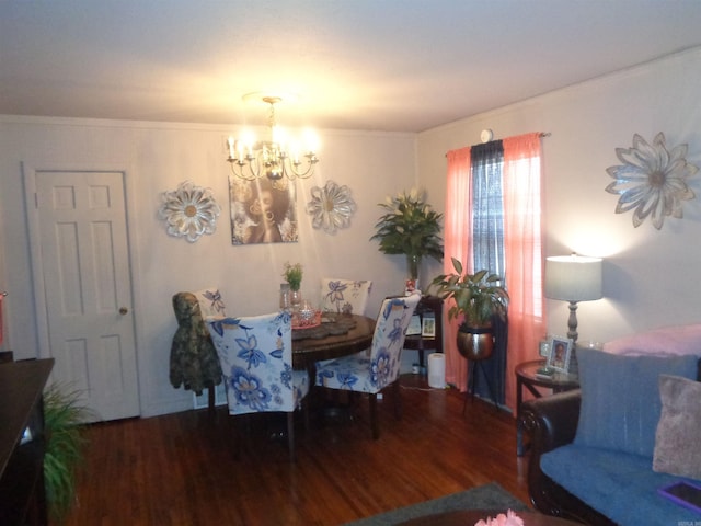 dining room with wood-type flooring, an inviting chandelier, and ornamental molding