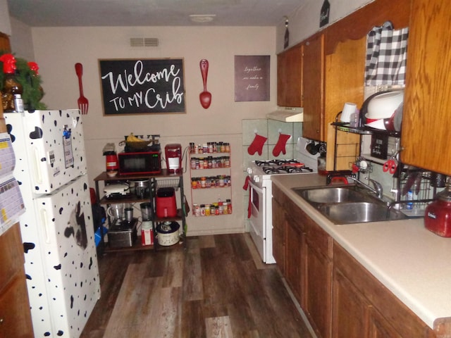 kitchen featuring sink, dark hardwood / wood-style floors, and white appliances