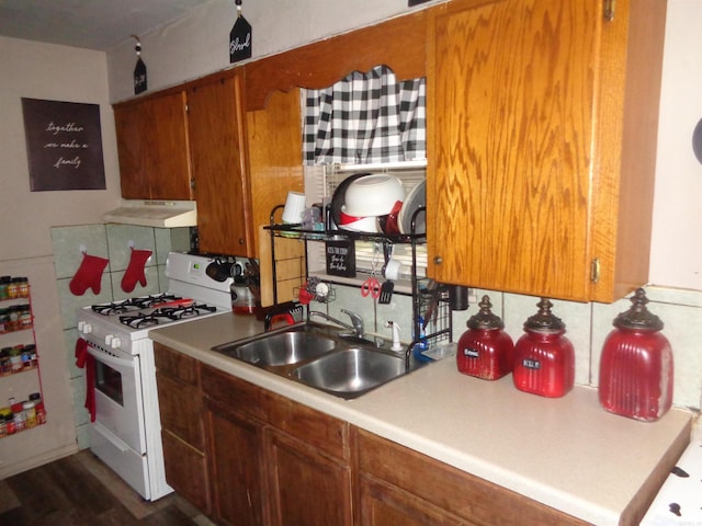 kitchen with dark hardwood / wood-style floors, sink, and white range with gas cooktop