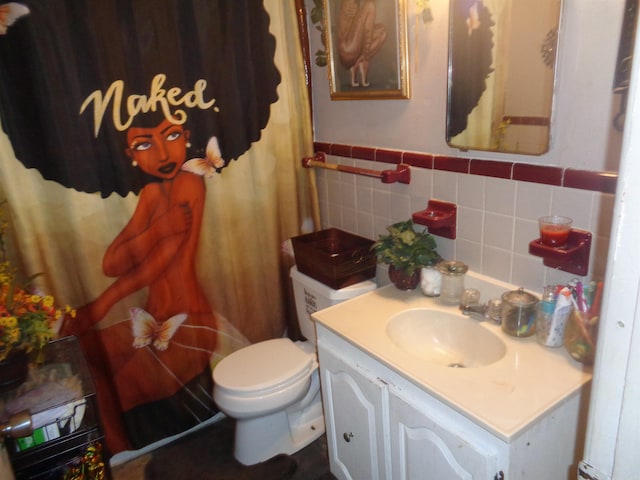 bathroom with vanity, tile walls, and toilet