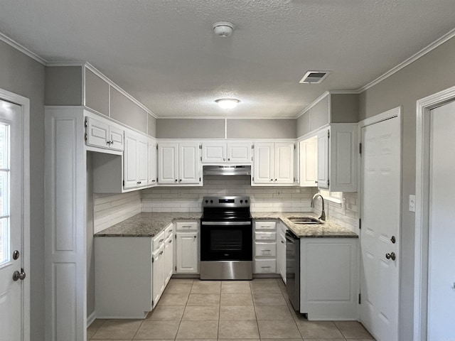 kitchen featuring appliances with stainless steel finishes, backsplash, sink, light tile patterned floors, and white cabinetry