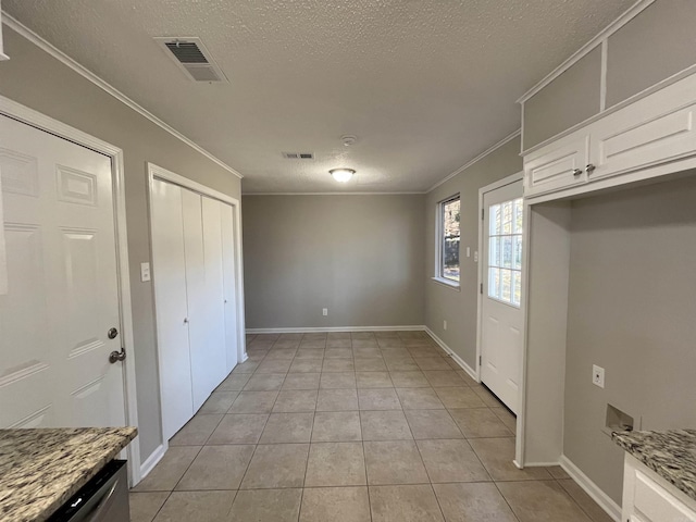 interior space featuring a textured ceiling, crown molding, and light tile patterned flooring