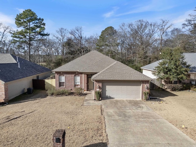 single story home with cooling unit and a garage