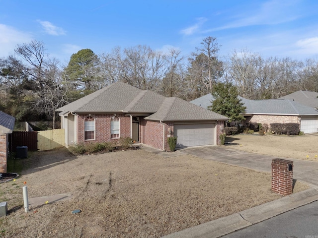 single story home with central AC unit and a garage