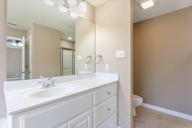 bathroom with tile patterned flooring, vanity, ceiling fan, and toilet