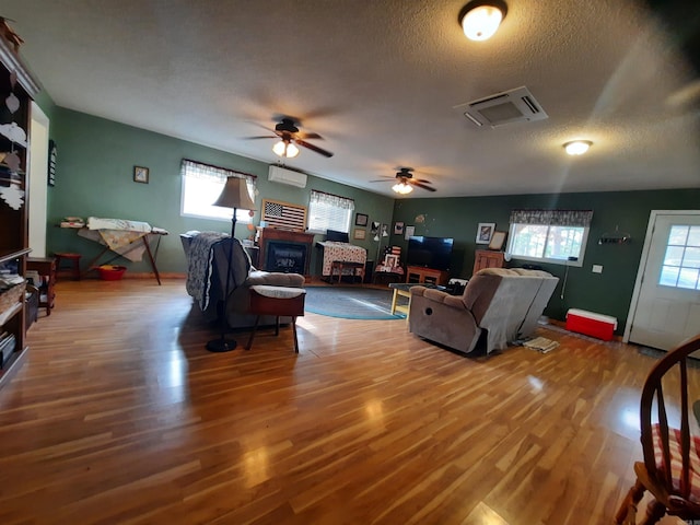 living room with hardwood / wood-style floors, plenty of natural light, and ceiling fan