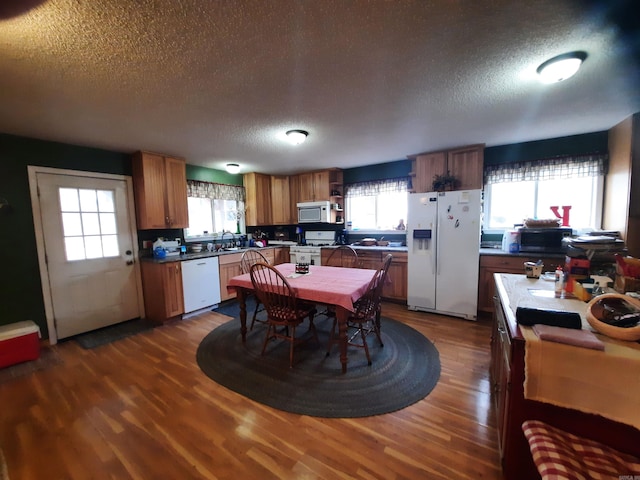 kitchen featuring dark hardwood / wood-style flooring, white appliances, and a textured ceiling