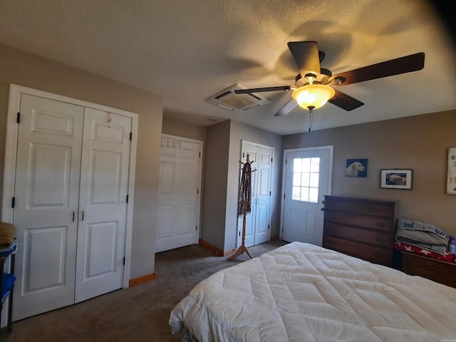 carpeted bedroom featuring a textured ceiling, ceiling fan, and multiple closets