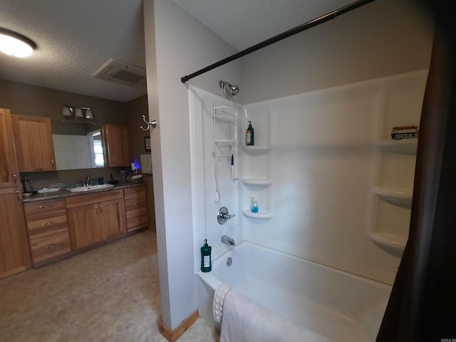 bathroom featuring vanity, a textured ceiling, and bathing tub / shower combination