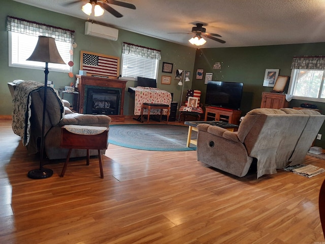 living room featuring a textured ceiling, plenty of natural light, and a wall mounted AC