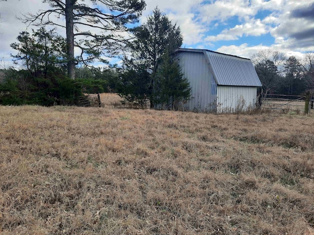 view of yard featuring a rural view and an outdoor structure