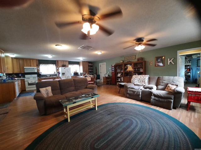 living room featuring light hardwood / wood-style floors and ceiling fan