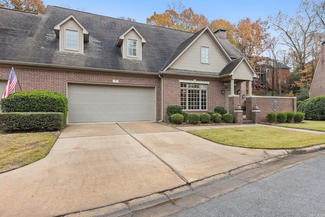 new england style home featuring a garage and a front lawn