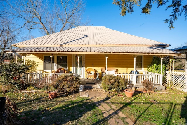 rear view of property with a lawn and a porch