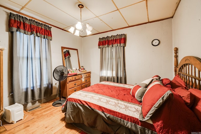 bedroom featuring multiple windows, a chandelier, and wood-type flooring