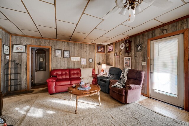 living room featuring ceiling fan and wood walls