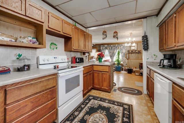 kitchen featuring pendant lighting, white appliances, decorative backsplash, kitchen peninsula, and a chandelier