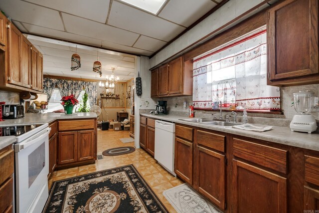 kitchen with a notable chandelier, white appliances, and sink