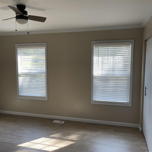 spare room featuring crown molding, ceiling fan, and light hardwood / wood-style floors