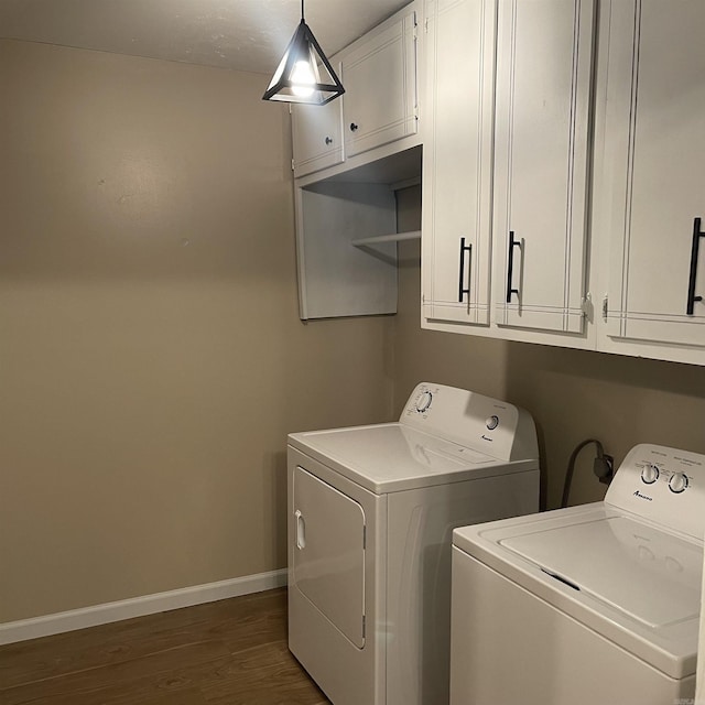 clothes washing area with dark hardwood / wood-style flooring, washer and clothes dryer, and cabinets