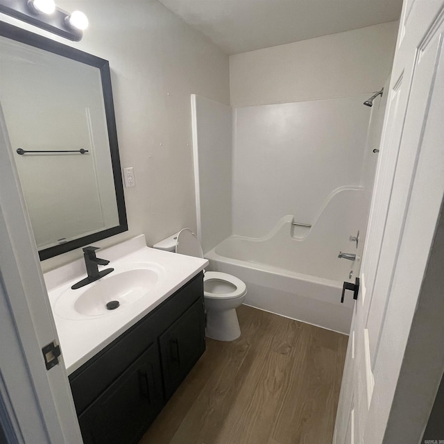 full bathroom with toilet, vanity, bathtub / shower combination, and hardwood / wood-style flooring