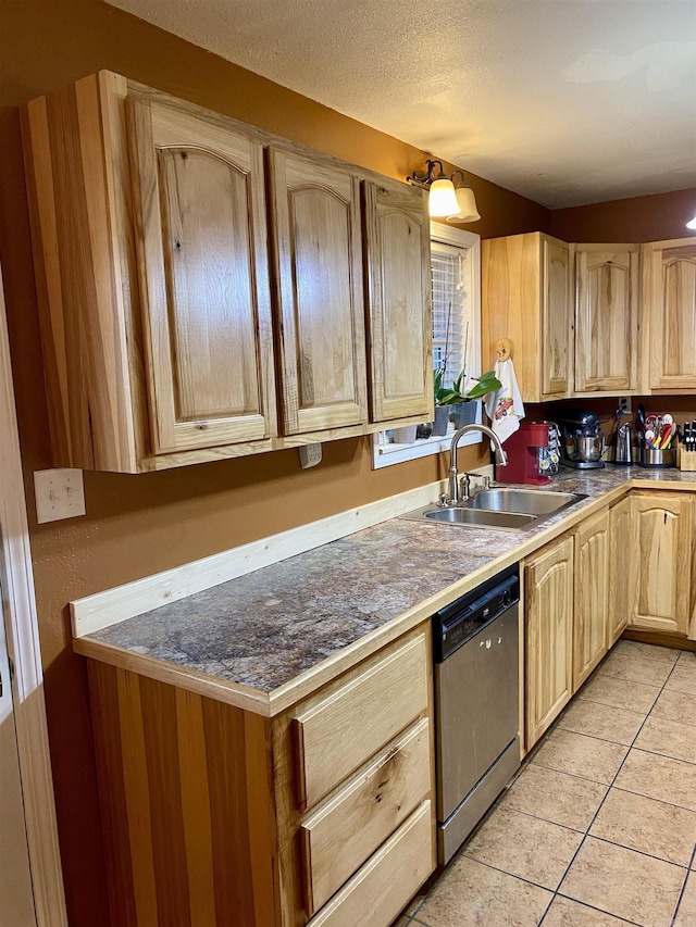 kitchen with sink, light brown cabinets, stainless steel dishwasher, a textured ceiling, and light tile patterned flooring